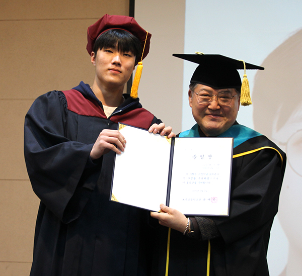 보은고 졸업생이 윤여찬 교장으로부터 졸업장을 전달받고 있다.