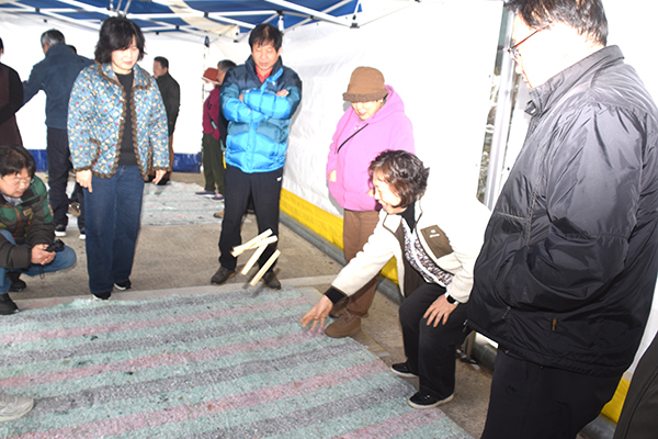 보은군귀농·귀촌협의회 회원들이 전통놀이에서 윷을 던지고 있다.